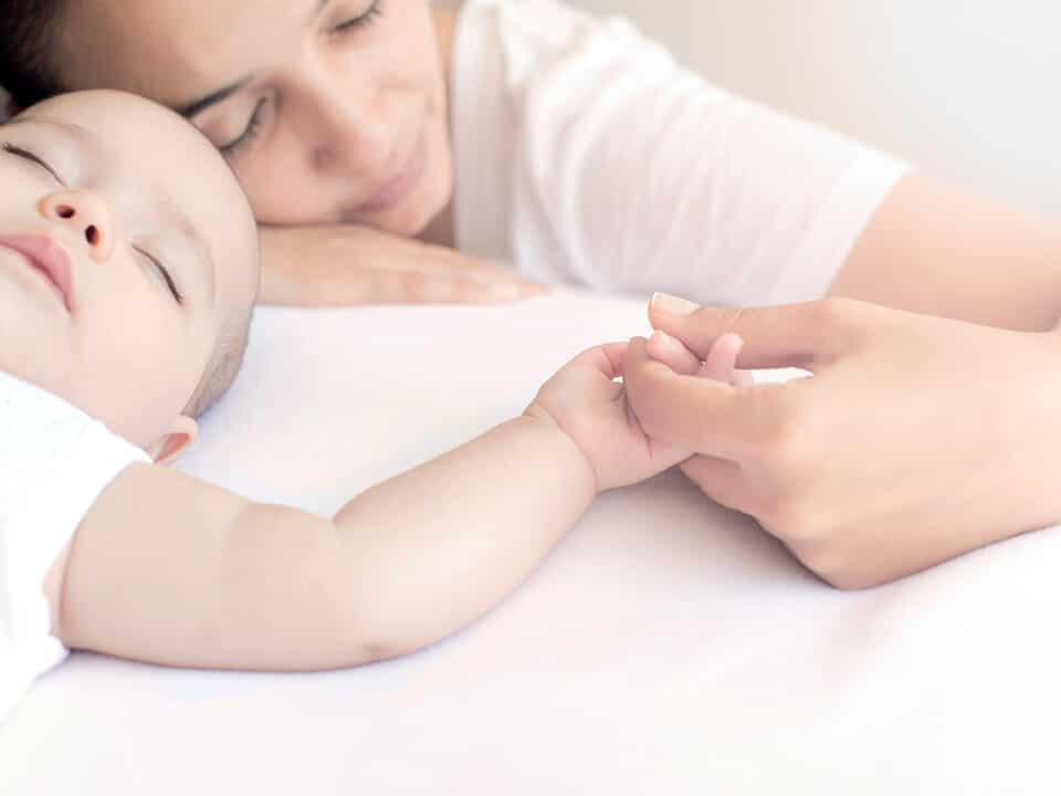 mãe segura a mão do seu bebê