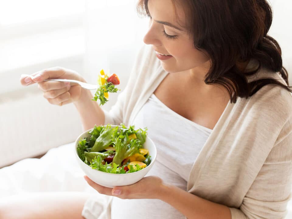 Gestante de alimentando de salada com variedade de cores